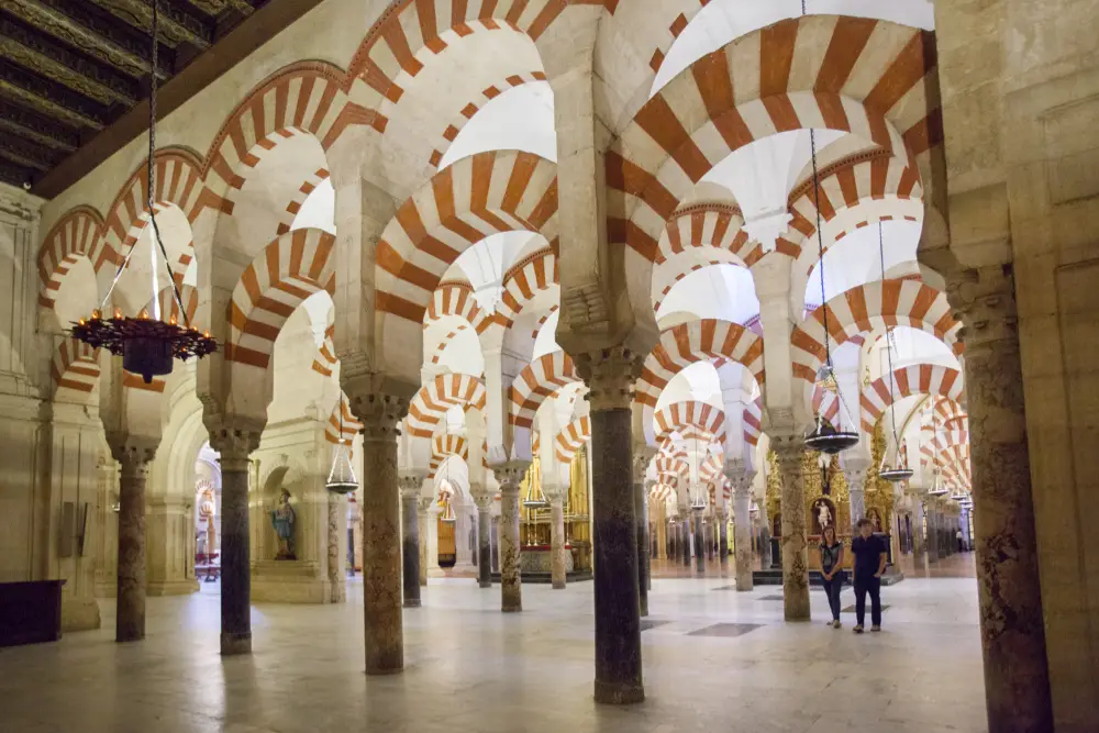 A short history of Córdoba’s Mezquita 2 inside the mezquita with row upon row of red and white brick arches supported by stone columns - andalucia.org - © TURISMO ANDALUZ