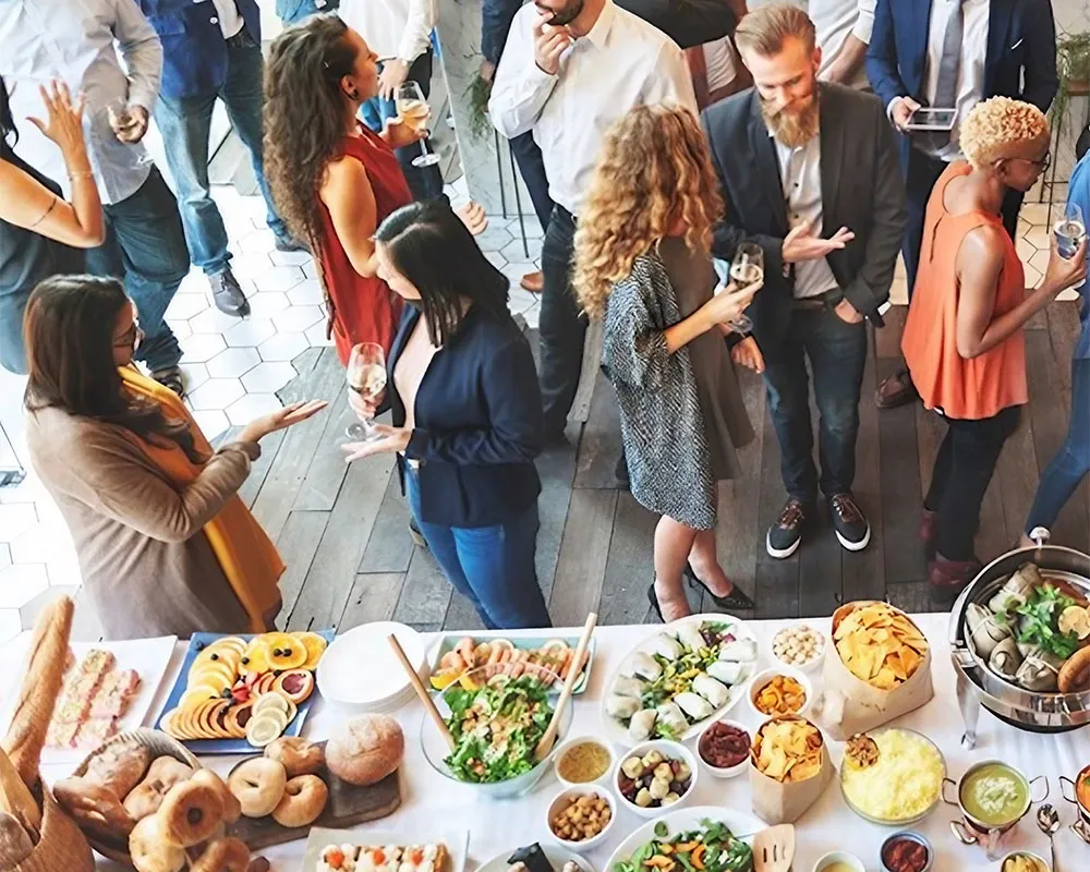 Group of colleagues chatting near table of sustainable food. Credit. Pexels
