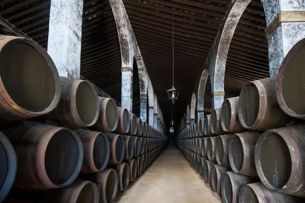 Why Sherry is the most misunderstood wine in the world 3 row upon row of sherry barrels. Created in Canva