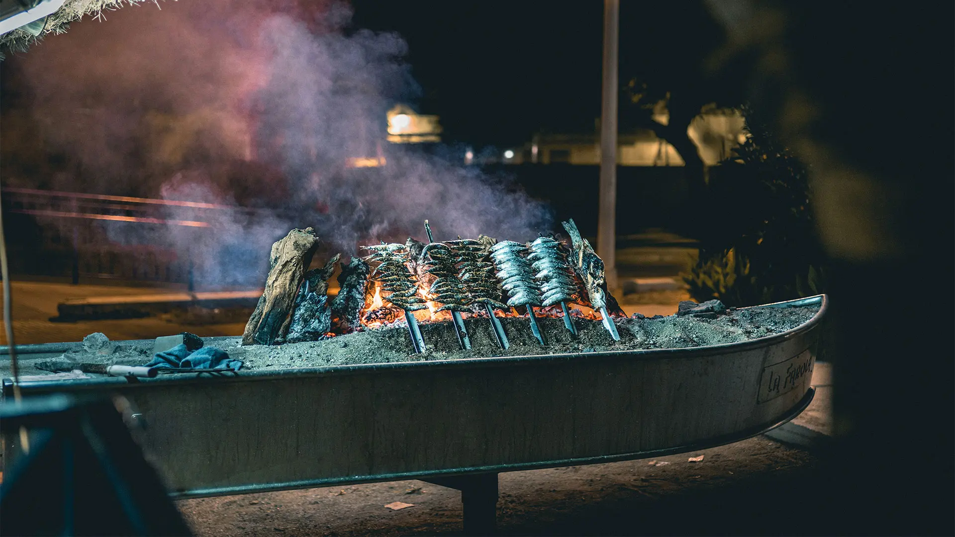 espeto in boat: Sardines cooked over an open fire in a sand-filled boat. This is called espeto in Malaga.