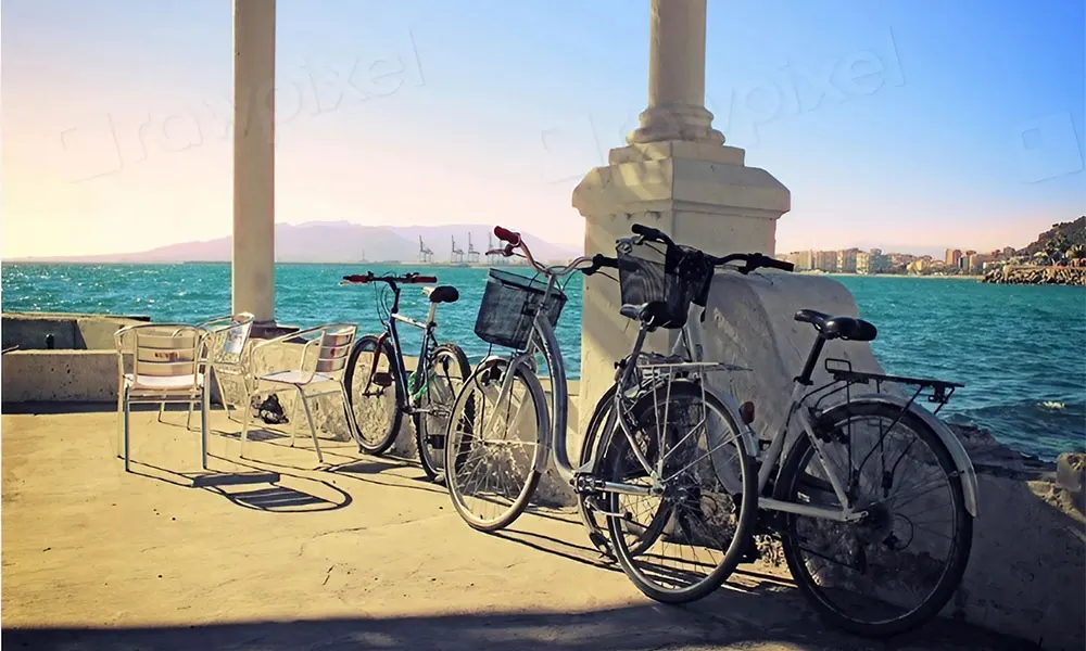 Bikes – Bikes leaning against the pillar, looking across the sea to Malaga