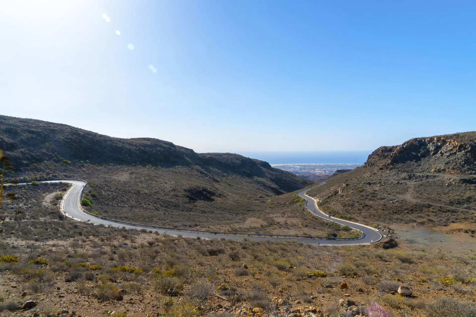 blue sky with road winding to the coast – an idyllic road trip. Photo by Marian Florinel Condruz: https://www.pexels.com/photo/gray-asphalt-road-between-green-grass-covered-mountains-under-blue-sky-4051232/