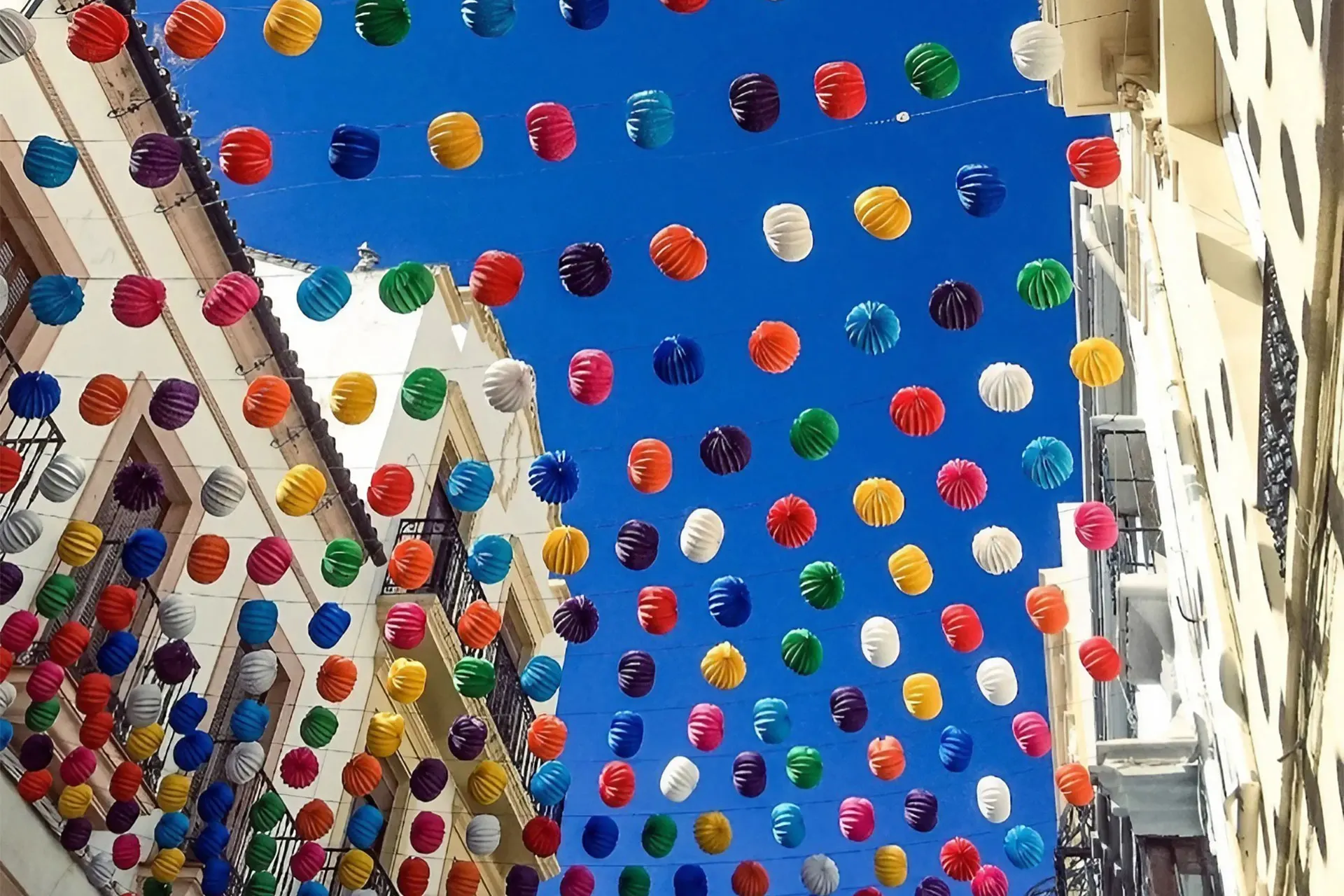 Colourful street bunting in Spain where the travel experiences sector is excelling.