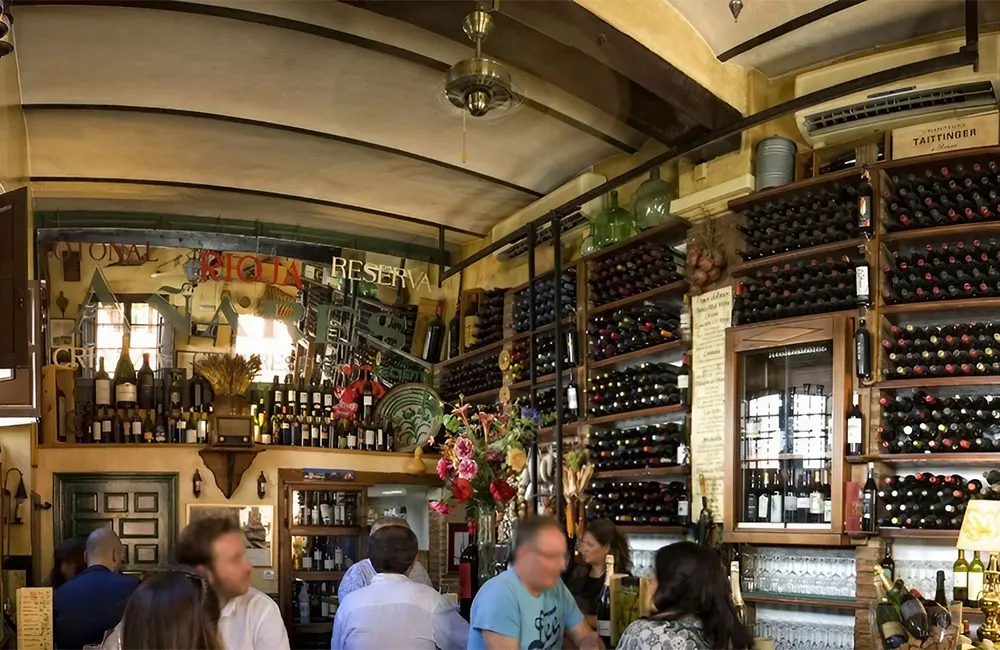 Interior of Taberna la Tana, Granada, lined with bottles of wine and sherry. Credit: TripAdvisor